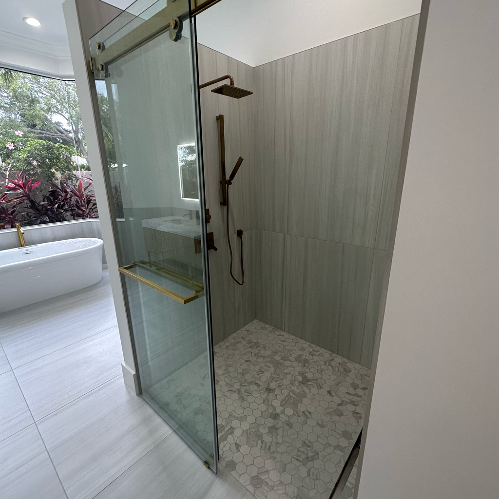 Walk-in shower with glass enclosure and brass fixtures in Palm Beach County